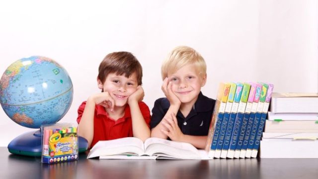 仲良く机に向かって勉強する男の子二人の画像