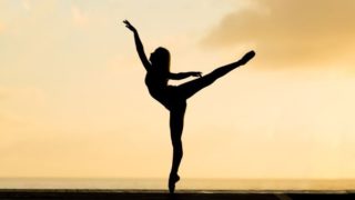 夕日を背にダンスのポーズをとる女性のシルエット画像