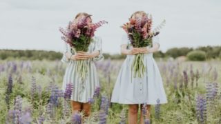草原に佇み花束を持つ二人の少女の画像